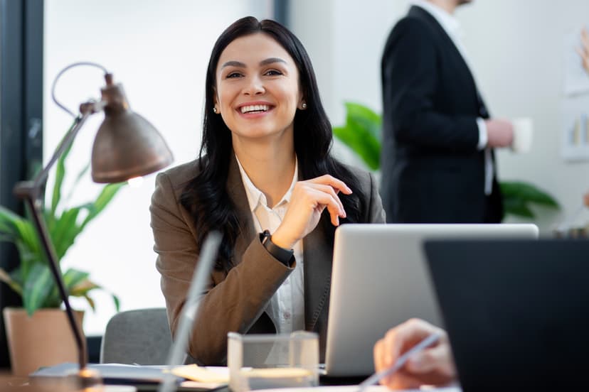 Professional woman smiling and working at her desk